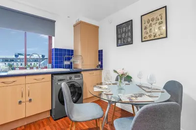 a kitchen with a table and a dishwasher at Modern 2 bedroom apartment in City Centre in Edinburgh