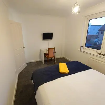 a bedroom with a bed with a yellow towel on it at RF-Entire House-Central Scotland-Falkirk, Self-Check-in , Pet-friendly and with Parking in Falkirk