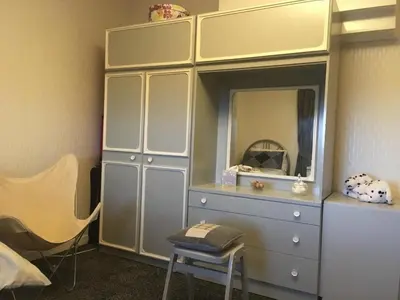 a dresser with a mirror and a chair in a room at Farmhouse in Clydebank