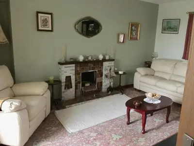 a living room with two couches and a fireplace at Farmhouse in Clydebank