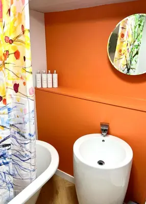 a bathroom with a white sink and a mirror at Tin Lid Cottage - cosy ground floor flat in Banton