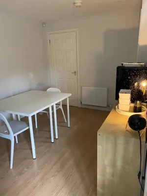 a white table and chairs in a room at Spacious & Modern Garden Apartment in Bearsden