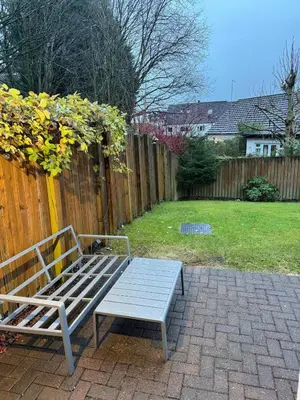 a bench sitting in a yard next to a fence at Spacious & Modern Garden Apartment in Bearsden