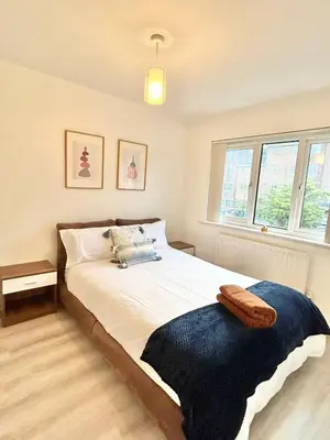 a bedroom with a bed with a blue blanket on it at KH-Entire House -Central Scotland, Self-Check-in , Pet-friendly and with Parking in Falkirk