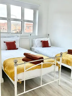 two beds in a room with white walls and windows at KH-Entire House -Central Scotland, Self-Check-in , Pet-friendly and with Parking in Falkirk