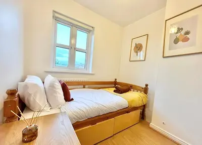 a bedroom with a bed with white sheets and a window at KH-Entire House -Central Scotland, Self-Check-in , Pet-friendly and with Parking in Falkirk