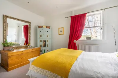 a bedroom with a bed and a sink and a mirror at Peace in the City in Edinburgh