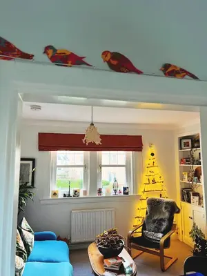 a living room with a christmas tree and a chair at Peace in the City in Edinburgh