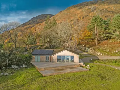a house on a hill with a wooden deck at Ferry House in Bonawe