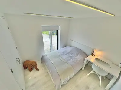 a bedroom with a bed and a desk and a dog at Ferry House in Bonawe