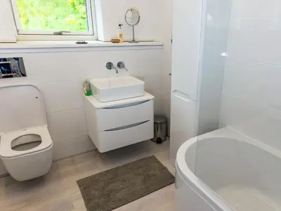a bathroom with a sink and a toilet and a tub at Ferry House in Bonawe