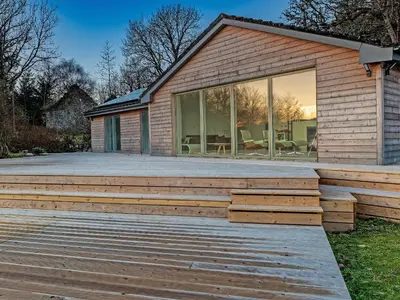 a house with a wooden deck in front of it at Ferry House in Bonawe