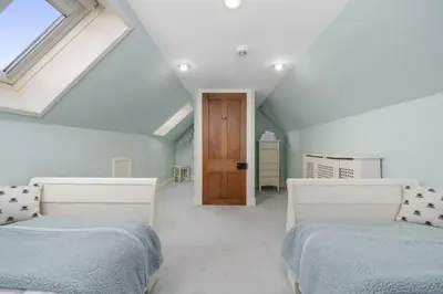 a attic bedroom with two beds and a skylight at The Strone Luss Premium Holiday Rental in Luss