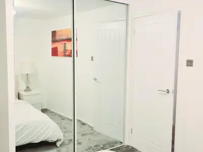 a glass shower door in a bedroom with a bed at Cozy Flat in Glasgow City Centre in Glasgow