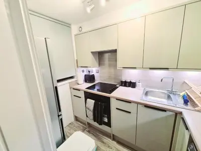 a kitchen with white cabinets and a sink at Cozy Flat in Glasgow City Centre in Glasgow