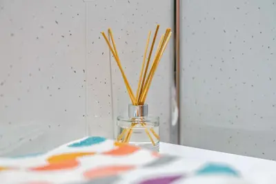 a glass vase with sticks in it on a table at Central Kirkintilloch 2 Bed App in Kirkintilloch