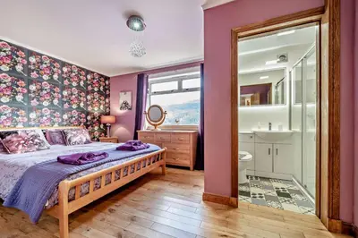 a bedroom with a large bed and a bathroom at 4 Bed in Lochgoilhead oc-j30107 in Carrick