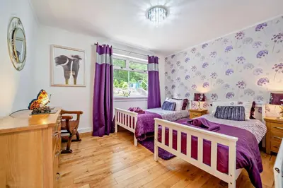 a bedroom with two beds and purple curtains at 4 Bed in Lochgoilhead oc-j30107 in Carrick