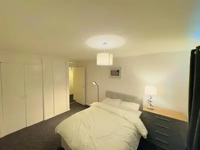 a bedroom with a large white bed and a lamp at Cosy flat in Glasgow in Maryhill