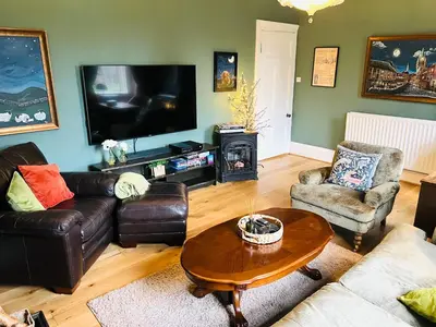 a living room with couches and a table and a television at Carvetii - Abbey View, 1st Floor Flat, City Centre in Dunfermline