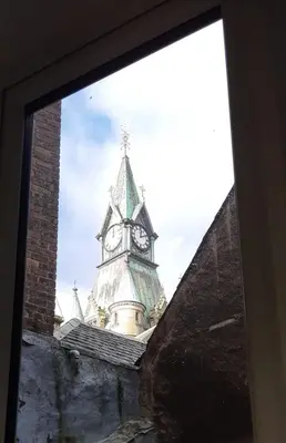 a clock tower is seen through a window at Carvetii - Abbey View, 1st Floor Flat, City Centre in Dunfermline