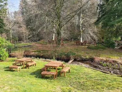 a group of picnic tables and benches in a field at The River Inn in Killin