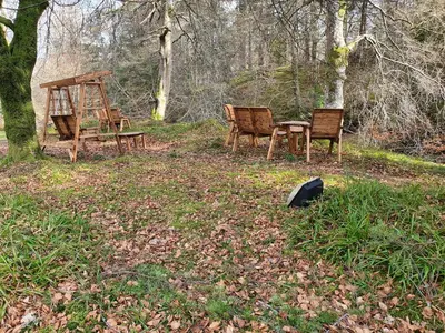 a group of chairs and a table in the woods at The River Inn in Killin