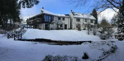 a house with snow on the ground in front of it at The River Inn in Killin