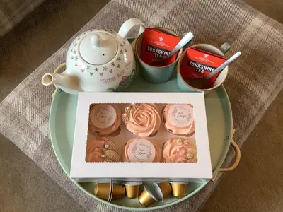 a table with a plate of cupcakes and a tea pot at 2 Bed in Rosyth oc-r30512 in Rosyth
