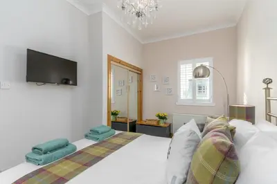 a bedroom with a white bed with a flat screen tv at 2 Bed in Rosyth oc-r30512 in Rosyth