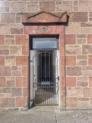 a door with a metal gate in a brick wall at Campbeltown Harbour View in Campbeltown