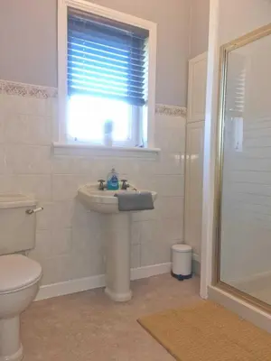 a bathroom with a sink and a toilet and a window at Campbeltown Harbour View in Campbeltown