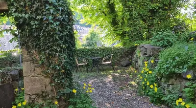 a garden with two chairs and a table and flowers at 17 Oban in Oban