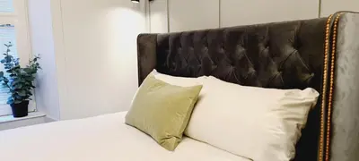 a bed with white pillows and a brown headboard at 17 Oban in Oban