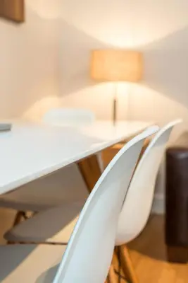 two white chairs next to a desk with a lamp at The Maltings in Edinburgh