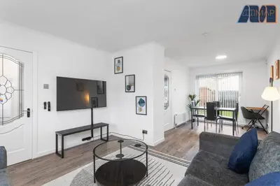 a living room with a couch and a tv on a wall at Modern 3 Bed Home in Bathgate with Garden in Armadale