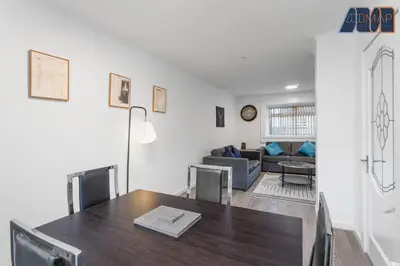 a dining room with a table and a couch at Modern 3 Bed Home in Bathgate with Garden in Armadale