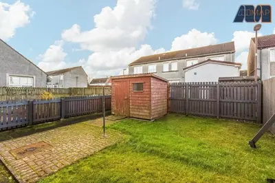 a backyard with a wooden fence and a smallshed at Modern 3 Bed Home in Bathgate with Garden in Armadale