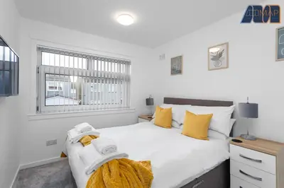 a bedroom with a large white bed with yellow pillows at Modern 3 Bed Home in Bathgate with Garden in Armadale