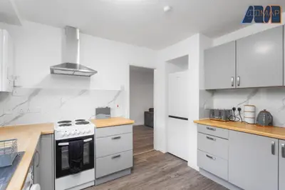 a kitchen with white cabinets and a stove top oven at Modern 3 Bed Home in Bathgate with Garden in Armadale
