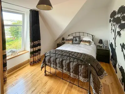 a bedroom with a bed and a window at Heatherdale in Dunoon