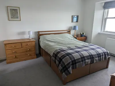a bedroom with a bed and a dresser and a window at Tigh Grianach in Port Charlotte