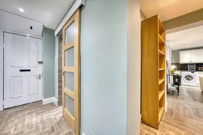 a hallway with a door leading to a kitchen and a laundry room at Stylish 3-Bedroom Apartment in Central Glasgow in Glasgow