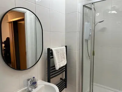 a bathroom with a mirror and a sink and a shower at Quiet 2 bedrooms and 2 bathrooms with free parking in Edinburgh