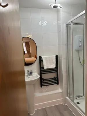 a bathroom with a sink and a shower and a mirror at Quiet 2 bedrooms and 2 bathrooms with free parking in Edinburgh