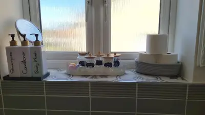 a counter with candles and cakes on a window sill at Innisfail Edi - double room with private bathroom in Edinburgh