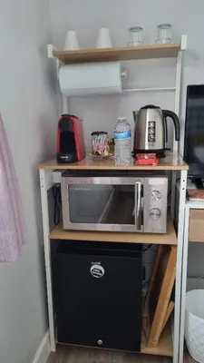 a microwave on a shelf in a kitchen at Innisfail Edi - double room with private bathroom in Edinburgh