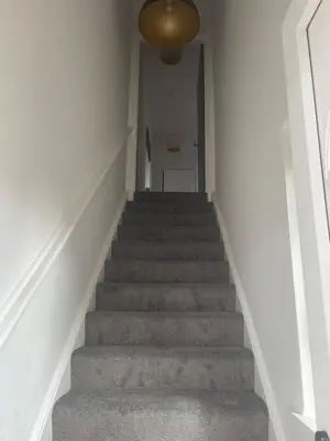 a stairway with a hallway leading up to a room at Spacious 3 bed flat- Free parking Edinburgh & Fife in Inverkeithing