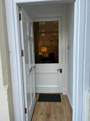 a door leading into a room with a hallway at Stunning refurbished main door Marchmont apartment in Edinburgh