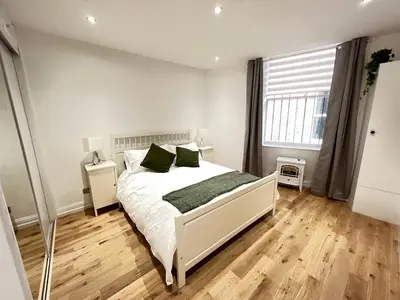 a bedroom with a white bed with green pillows at Stunning refurbished main door Marchmont apartment in Edinburgh